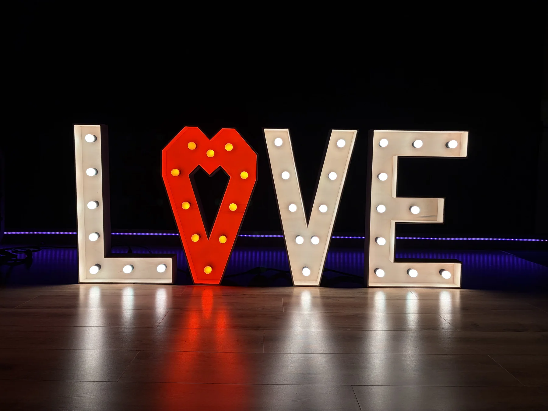 LOVE lichtletters in warm wit met een rood pompeblêd